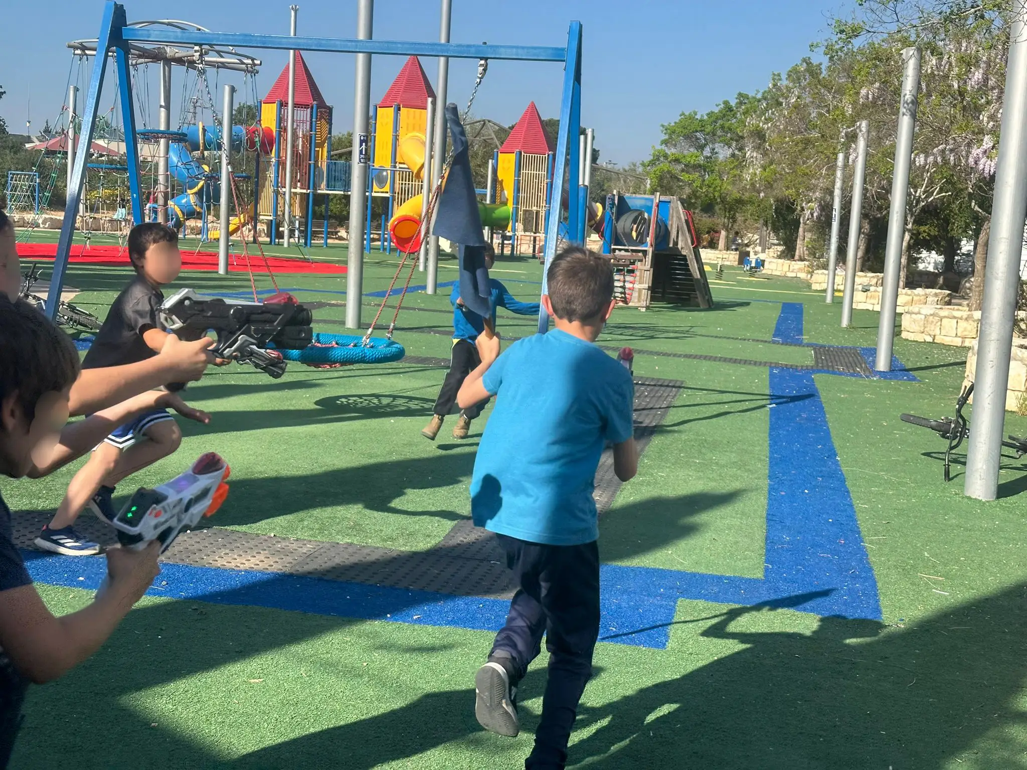 ילדים רצים עם רובי לייזר במגרש משחקים ביום